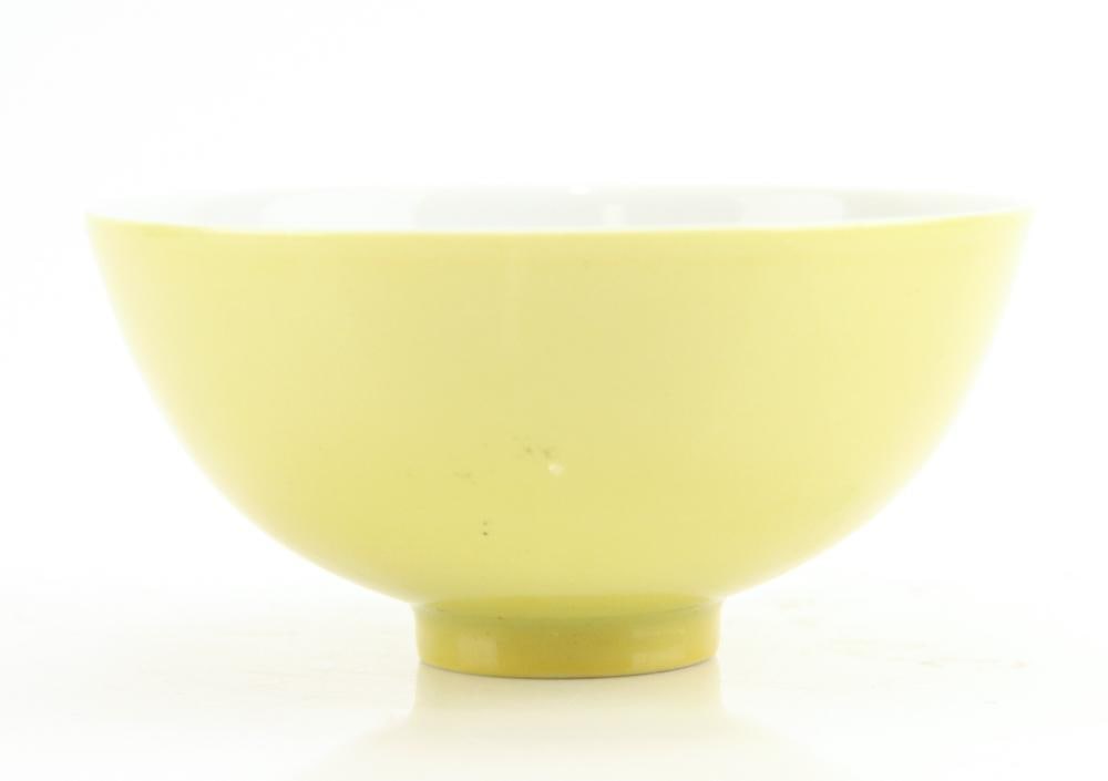 A Chinese Lemon-yellow Enameled Wine Cup: The thinly potted rounded sides rise from a short tapered ring foot. The exterior is evenly covered with a bright lemon-yellow enamel and the interior and base are applied with a white glaze. On the b
