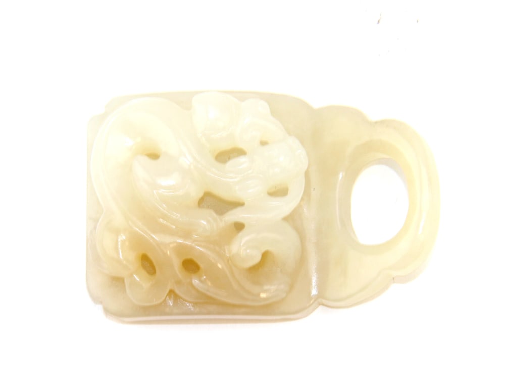 A Chinese Jade Buckle: A Chinese carved jade buckle with dragon design. 2 1/2 inches High and 2 inches Wide.