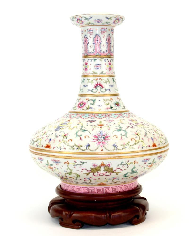 A Chinese Famille Rose Vase: The porcelain vase is enameled on the body with lotus blossoms borne and Buddhist Eight Treasures motif on scrolls, below a blue and pink RuyiÂ band. Gilt on the rim and covered turquoise-green glaze