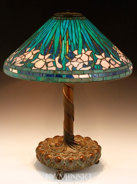 Leaded Glass and Bronze Lamp: Leaded glass and bronze lamp in the manner of Tiffany Studios, daffodil pattern shade in blue and green, bronze base with applied scrolled and wrapped vine work, both parts stamped, 25 1/4"h x 20"d. B