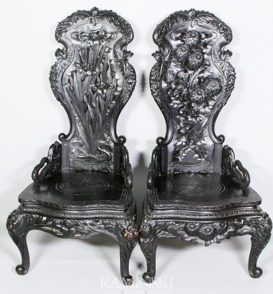 Pair of 19th C. Japanese Carved Chairs: Pair of carved chairs, Japan, 19th century, black ebonized wood, the seat backs carved with chrysanthemums and irises, and dragons on the seat, 50" h x 23" w x 20" d.