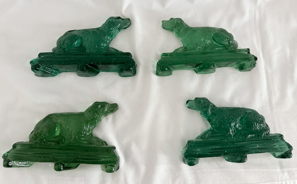 Group of Green Glass Dogs: Group of green glass dogs, 4" x 6 1/2" x 1", (4) total. Provenance: Estate of Howard D. Monroe, Jr., West Palm Beach, Florida.