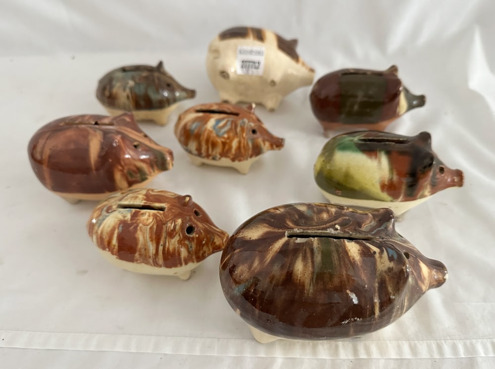 Group of Glazed Stoneware Piggy Banks: Group of (8) glazed stoneware piggy banks, largest 3 1/4" x 5" x 3". Provenance: Estate of Howard D. Monroe, Jr., West Palm Beach, Florida.