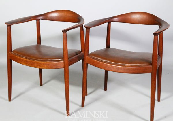 Pair Hans Wegner Armchairs: Pair of Hans Wegner armchairs, "the chair", or "the round chair", red-brown finish with brown leather seats, circa late 1950s/ early 1960s, likely early contract furniture, they are not marked save a