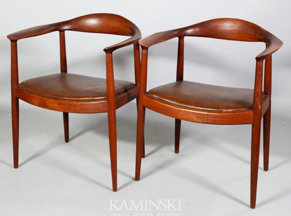 Pair Hans Wegner Armchairs: Pair of Hans Wegner armchairs, "the chair", or "the round chair", red-brown finish with brown leather seats, circa late 1950s/ early 1960s, likely early contract furniture, they are not marked save a