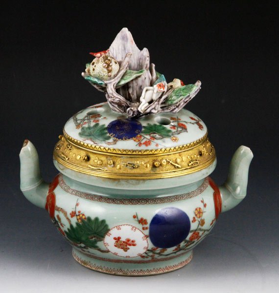 Chinese 19th C. Celadon Teapot: Celadon glazed teapot, China, 19th century, having double spout with ormolu bronze border, 8” x 7 1/2”.