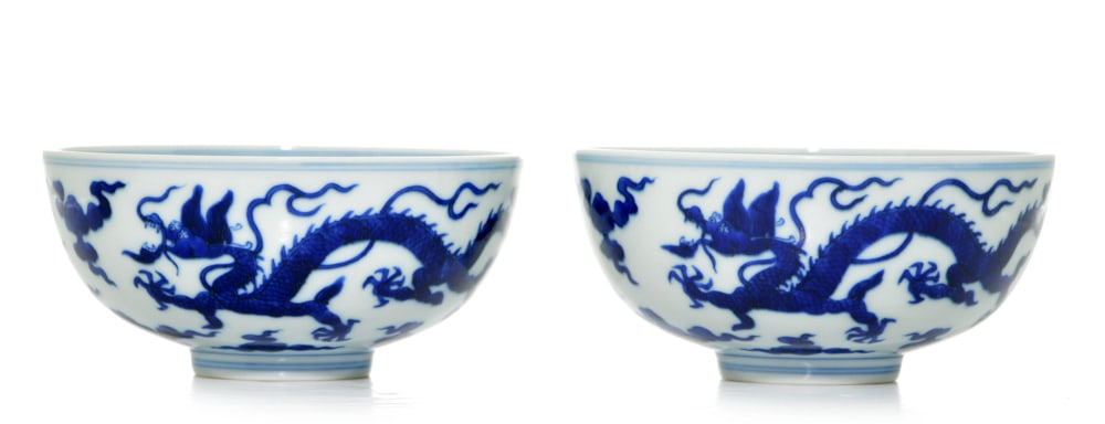 Pair of Chinese Blue and White Bowls: The bowls are painted around the exterior with two striding five-clawed dragons amongst clouds. The interior is decorated with a writhing dragon within a medallion. Daoguang mark. 6 1/4" diameter (16 
