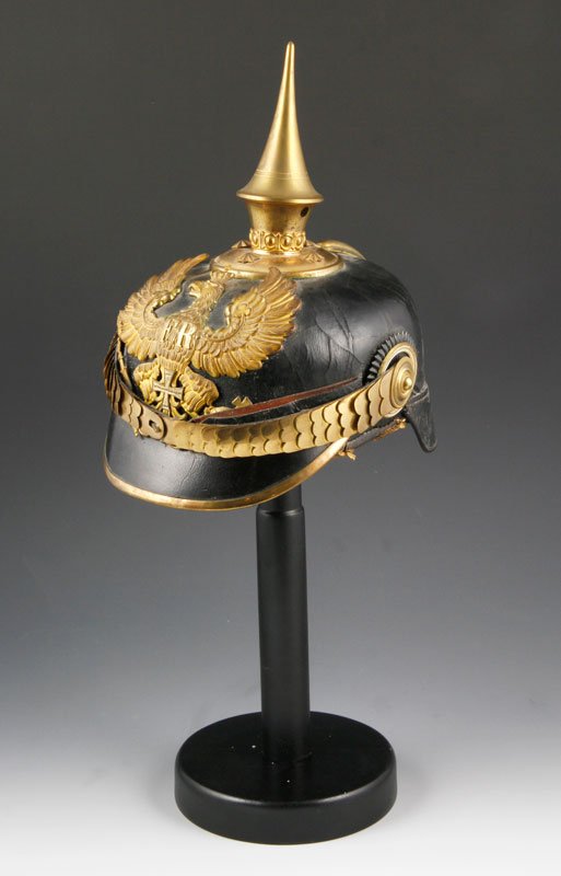 Prussian Pickelhaube: Prussian pickelhaube, leather with brass spike, eagle plate with iron cross, cockades and chin strap, retaining original liner, 9 1/2"h x 9"l x 7"w. Some dry cracking of leather.