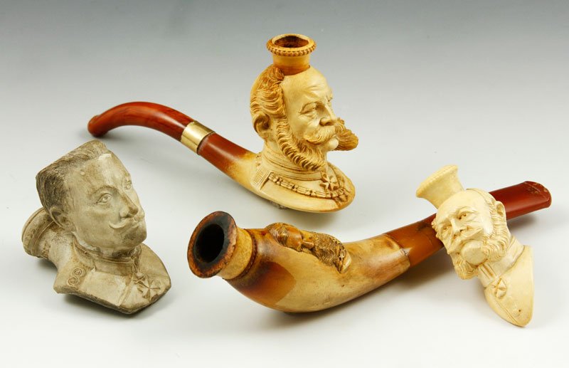 4 Prussian Carved Pipes: Lot of four Prussian craved pipes, one clay and three meerschaum, clay one marked Kaiser Wilhelm II 15 June 1888, two with stems and leather cases. Clay one with small chip.