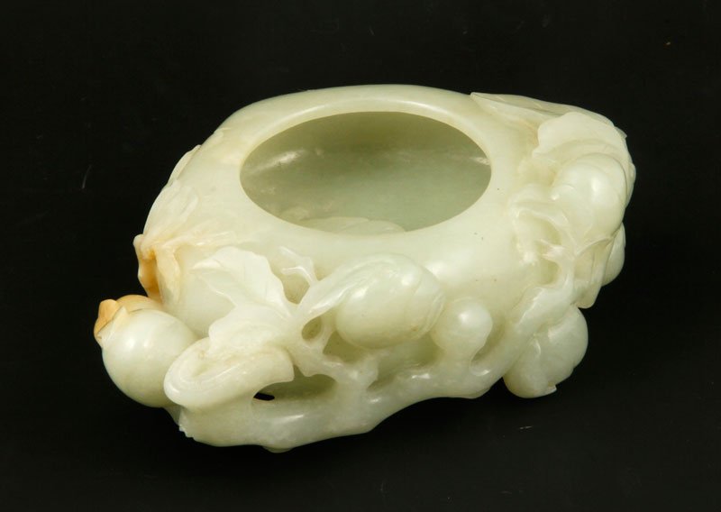Chinese Jade Brush Washer: Carved jade brush washer, China, the peach-shaped form decorated with eight additional peaches on a branch and carved with a bat on the inside of the washer, 6" l x 4 1/2" w x 2" h.