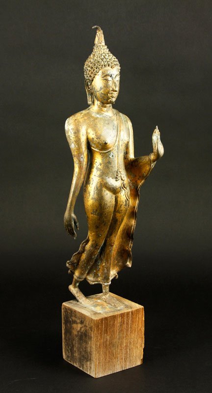 Southeast Asian 19th C. Bronze Buddha: Bronze figure of Buddha, Southeast Asian, possibly Thailand, 19th century, in standing pose, with gold leaf and on wood base, 16" x 4 1/2", on base 20" h.