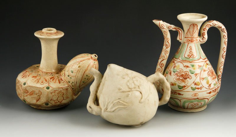 Vietnamese Porcelain Vessels: Lot of three porcelain vessels, Vietnam, to include one rare Kendi, decorated with lotus flowers around the nine-sided body, 6 1/2" h; one red and white glazed ewer, 20th century, 8" h; one white teap