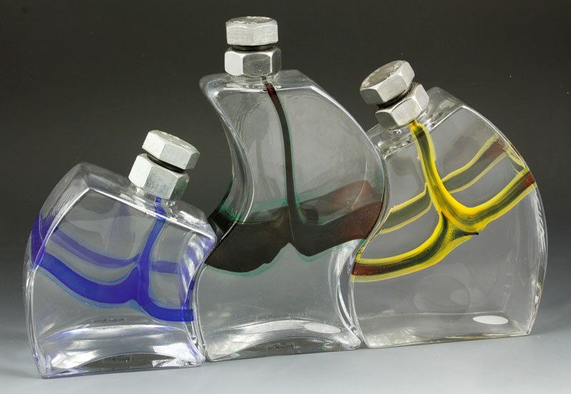 Kjell Engman Kosta Boda Decanters: Kjell Engman set of three Kosta Boda designer decanters, signed 9 1/2" h; 8 1/2" h; 6 1/2" h, with bolt spouts.