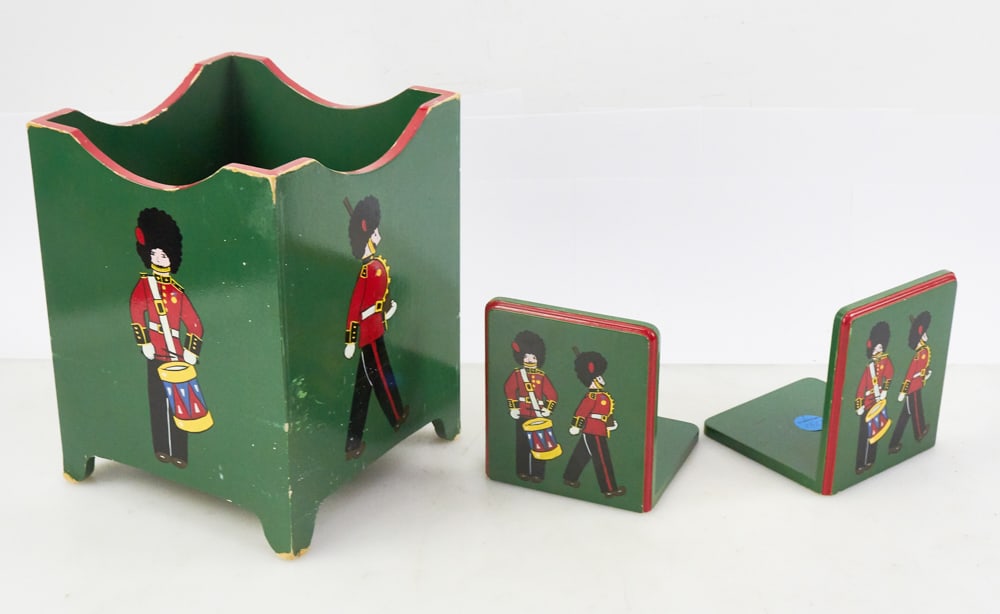 Vintage Painted Wastebasket, Queen's Guard Bookends: Vintage painted wood wastebasket , 11" x 8" x 8", and British Queen's Guard bookends, 6" x 5". Lot of (3). Provenance: The Susie Hilfiger Collection.