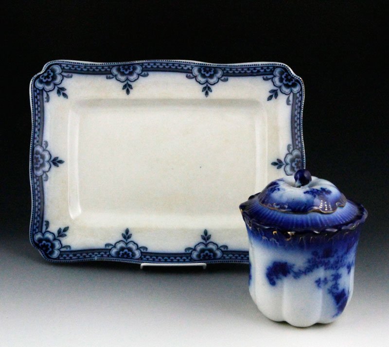 Lot of 2 Pieces Victorian China: Two pieces Victorian flow blue china, including a 7 1/2"h cracker jar, with a cylindrical lobed body with angled shoulder and domed lid, very dark with floral sprigs and gilt trim, circa. 1890s, and a