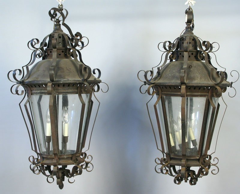 Pair of Hanging Lanterns: Pair of hanging lanterns with scroll decoration, painted metal with glass panes, 36"h x 20"dia. Provenance: From the 20th Century Props lighting collection in Hollywood, C.A.
