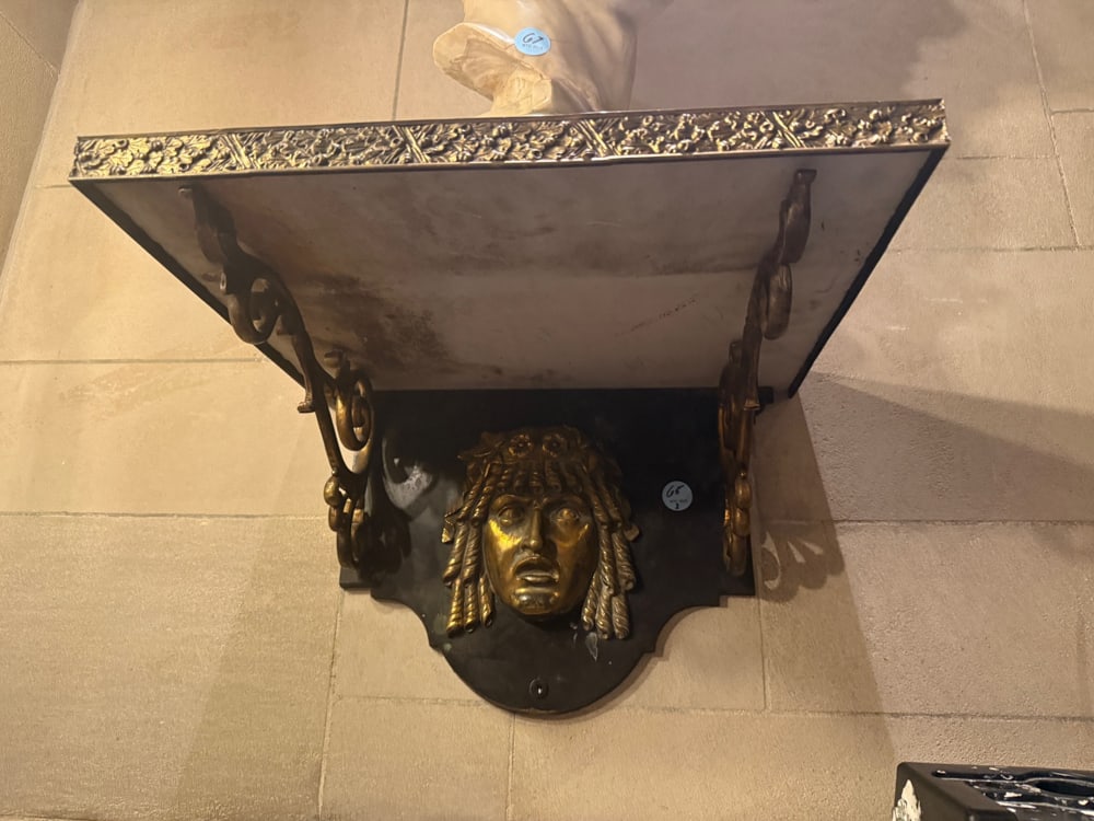 PAIR OF NEOCLASSICAL STYLE BRASSED AND PATINATED-BRONZE BRACKETS: A PAIR OF NEOCLASSICAL STYLE BRASSED AND PATINATED-BRONZE BRACKETS Each with rectangular rest supported by a cartouche-form backplate with a Classical mask and scrolling supports (part located in the 