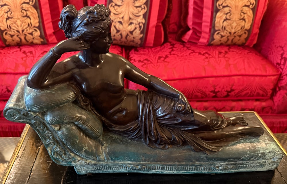 NEOCLASSICAL STYLE BRONZE AND COPPER PATINATED METAL RECLINING NUDE: A NEOCLASSICAL STYLE BRONZE AND COPPER PATINATED METAL FIGURE OF A RECLINING NUDE Depicted wearing drapery robes and sitting on a pillowed recamier Height: 11 1/2 inches Width: 17 inches Christie's Ap