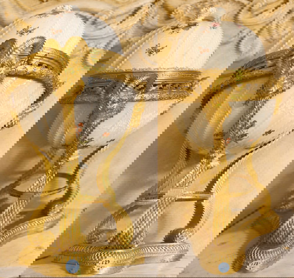 PAIR OF LOUIS XVI STYLE DRESDEN PORCELAIN COVERED URNS: A PAIR OF LOUIS XVI STYLE ORMOLU-MOUNTED DRESDEN PORCELAIN COVERED URNS Painted with fruit and flower sprays, with ram's mask-headed scrolled supports Height: 23 inches (2) Christie's Appraisal 2005 -