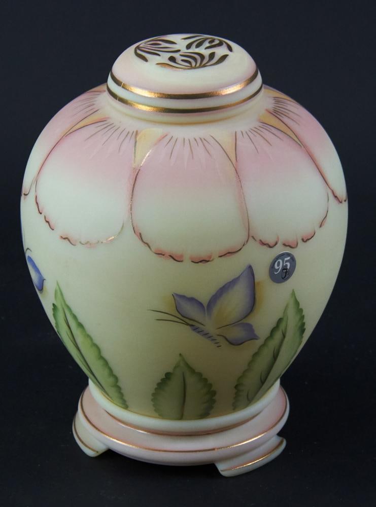 Fenton 95th Anniversary Burmese Glass Jar and Stand: Fenton 95th anniversary piece, hand-decorated Burmese glass covered jar and stand, 8" H x approximately 6 1/2" diameter. Good condition. Provenance: Estate of Dalia Zikas, Melrose, Massachusetts.