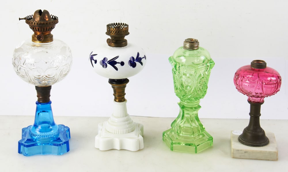 Group of 19thC Oil Lamps: 19th century oil lamps, to include: one with white cut to cobalt overlay font; one apple green font and base; one cranberry font on marble base; one Sandwich "owl and shield" pattern with etched leave