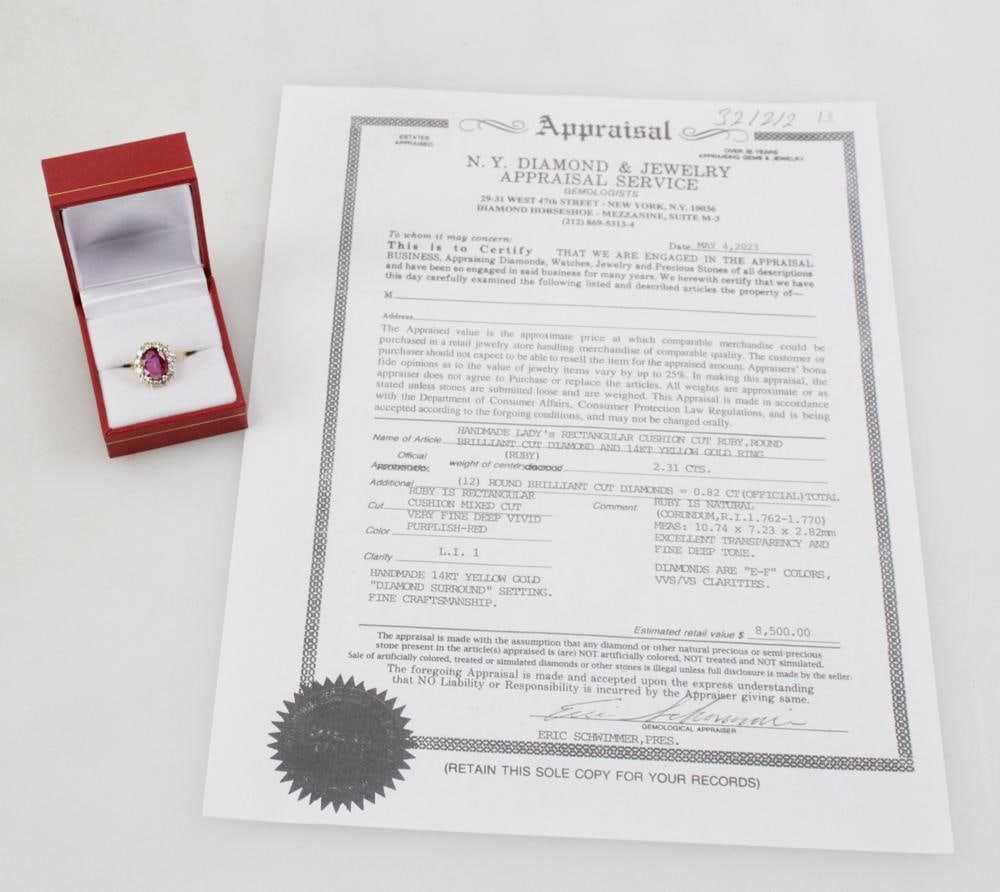 14k Yellow Gold, Ruby and Diamond Ring: Ruby and diamond ring in 14k yellow gold. Oval mix cut ruby, approximately 2.31 cts, extremely clean, excellent transparency; (12) round brilliant cut diamonds, approximately 0.82 ctw, E-F color,