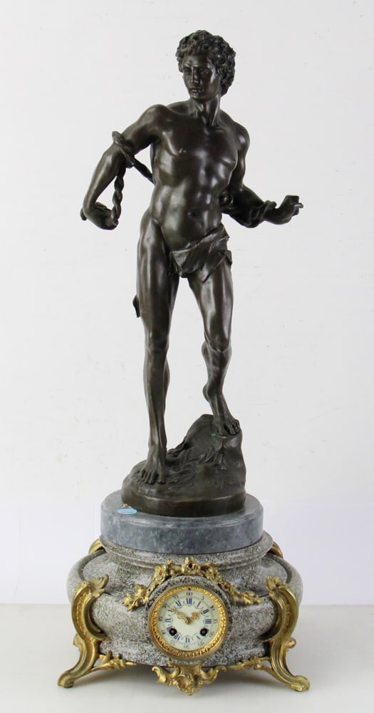 19thC French Large Classical Figure Bronze Clock: 19th century French large male classical solid bronze figure clock with gray marble round clock base, ormolu mounts. Clock 7" H x 13" diameter, figure 25" H (overall 32" H). Missing key and pendulum.