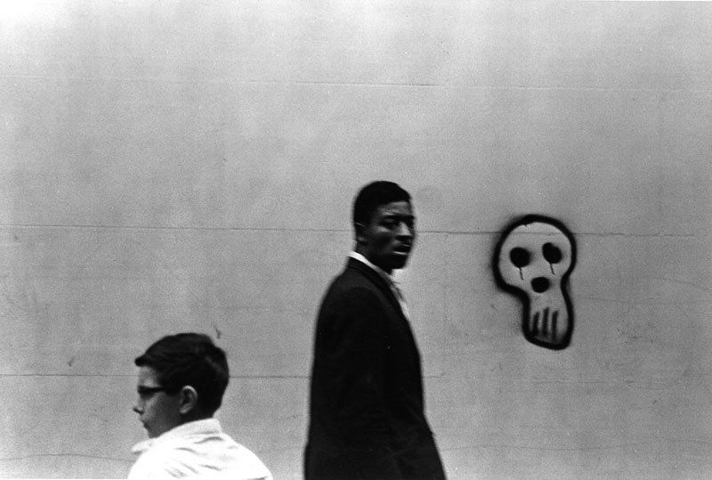 4 Photographs by DeCarava: Four photographs, Roy DeCarava (American 1919 - 2009), to include: "Woman walking, above", 1950; "Boy, Man and Graffiti" 1966; "Ketchup bottles, table and coat", 1952; "Man coming up subway stairs", 1