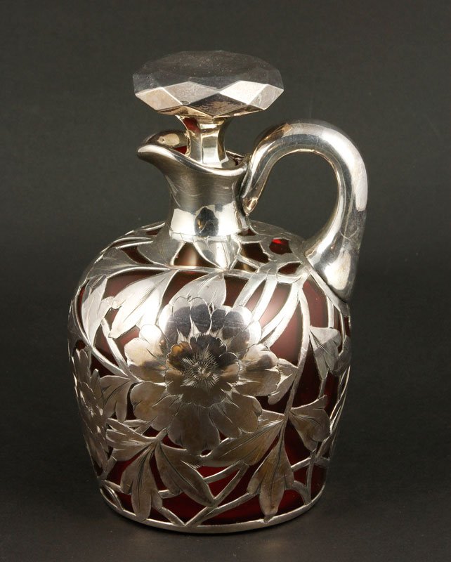 Sterling Overlay Glass Pitcher: Ruby glass pitcher with sterling silver overlay, with stopper, 7 1/2"h. Cracks to neck interior.