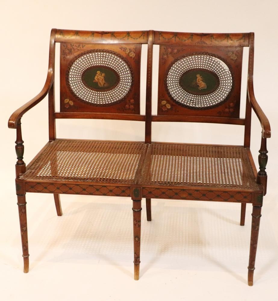 Adam-Style Bench With Cane Back and Seat: Adam-style bench having hand-painted swag decoration, cherub medallions, with cane back and seat, 36" H x 38" W x 26" D. Provenance: Palm Beach, Florida estate. PLEASE NOTE: This lot is not from