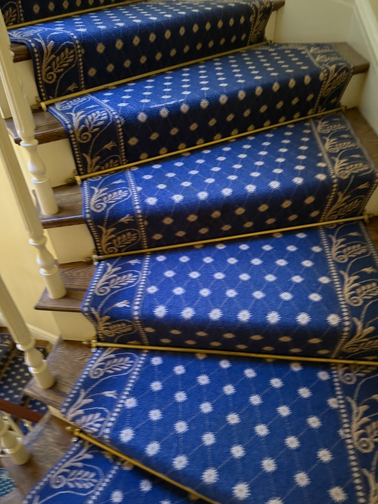 Custom-made Blue Staircase Rug with Floral Border: Custom-made blue staircase rug having a gold floral design on border. Includes brass stair rods. 2' 9" W, 4' 9" W at turn; 34' L. PLEASE NOTE: Item to be picked up at 129 Commonwealth Ave, Boston. Dea