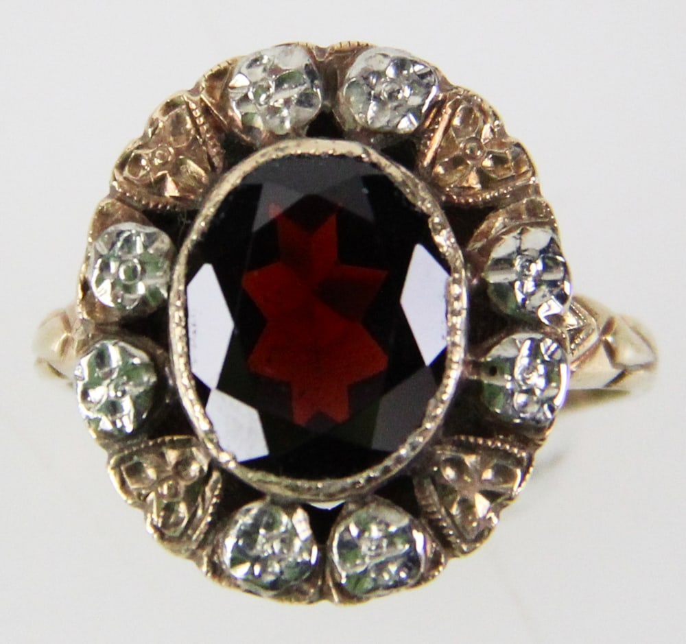 14k White and Yellow Gold Garnet Ring: 14k white and yellow gold ring with oval garnet and floral halo, size 5 1/2. Approximately 3.01 grams TW with stones. Provenance: Miami Beach, Florida collection. PLEASE NOTE: payment for silver, gold