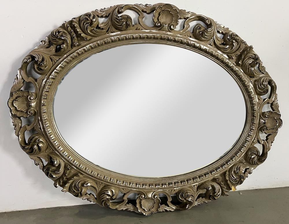 19thC English Silver Gilt Oval Beveled Glass Mirror: 19th century English silver gilt oval beveled glass mirror with carved foliate and shell design, 40 1/2" x 52". Provenance: Vero Beach, Florida collection.