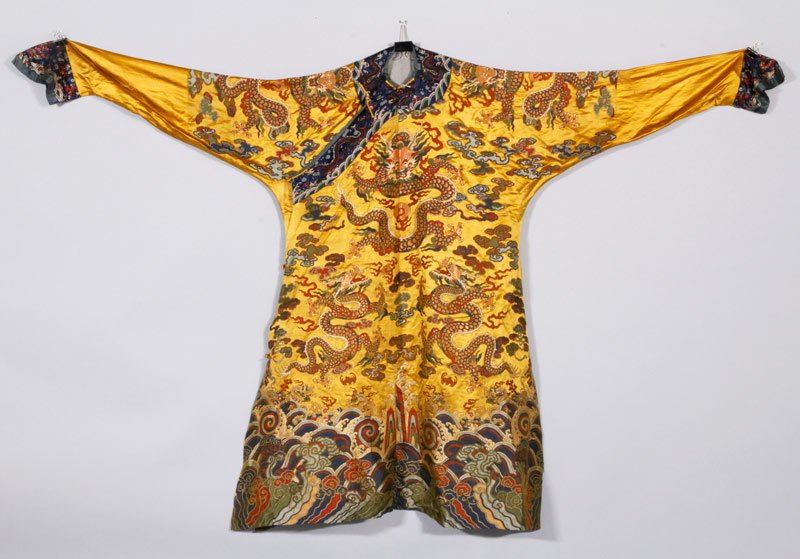Chinese Embroidered Dragon Robe: Embroidered dragon robe, China, with a design of multiple dragons on a yellow silk ground, a wave border at the hem and a blue silk lining, 49" x 88".