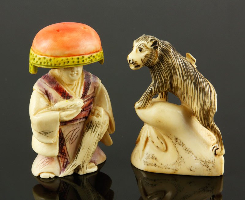 Carved Ivory Netsukes: Two carved ivory netsukes, Japan, carved in the form of a tiger and a monk, largest 2" h.