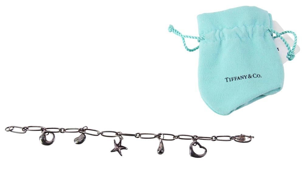 Signed Tiffany and Co. Sterling Bracelet with Charms: Signed Tiffany and Co. sterling bracelet with (5) charms, 8" L, in original Tiffany suede bag. Approximately 0.49 troy oz TW. Provenance: Littleton, Massachusetts collection. PLEASE NOTE: payment for 