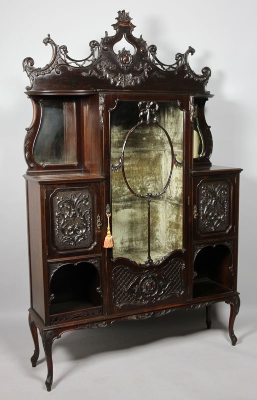 Late Victorian Mahogany Cabinet: Late Victorian carved dark mahogany display/side cabinet, the molded cornice above a glazed cupboard door with ribbon tired oval central panels and blind fret lattice work panel to the base, enclosing