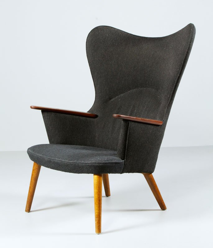 Hans Wegner “Mama Bear” Chair: Hans Wegner “Mama Bear” chair, in black wool upholstery, teak frame and walnut handrests, c. 1950s, Denmark, not visibly marked, 42 1/4” h x 33” w x 23” d. Previously from the Estate of Dr.