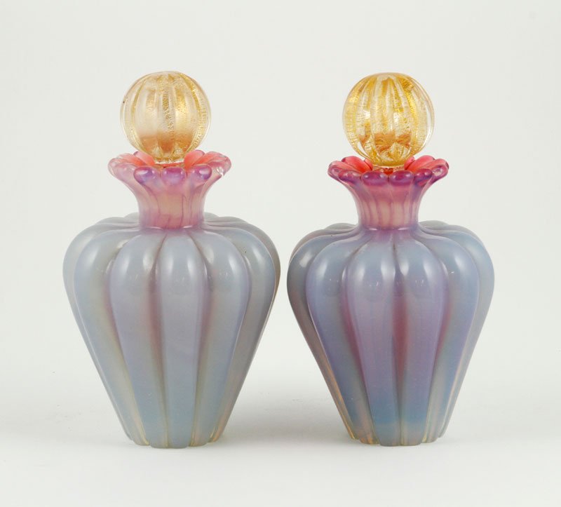 Pair Murano Glass Perfumes: Pair of Murano glass perfumes in pink and pale lavender incamiciato glass, stoppers on both with applicazion di foglia d'oro, cased in cristallo, 6 1/2"h x 3"w. Provenance: Collection of Robert Loy.