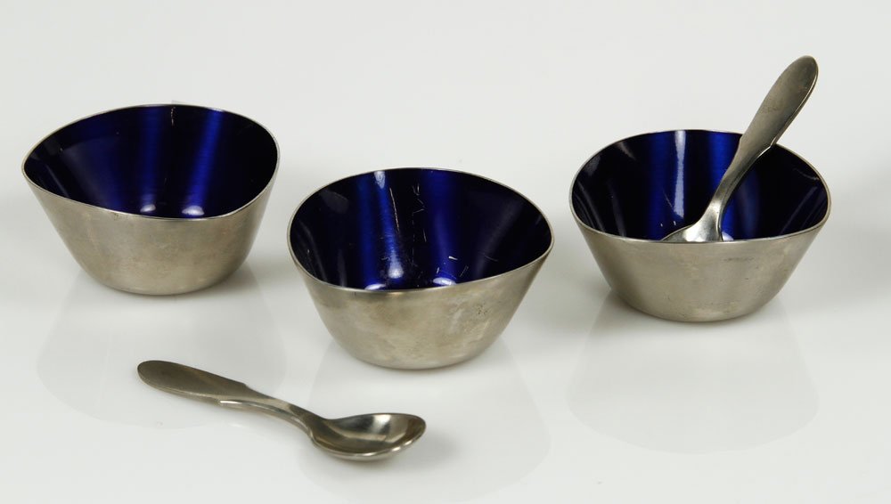 3 Jensen Salt Cellars and Spoons: Set of three Georg Jensen salt cellars with two spoons, stainless steel, bowls with enameled cobalt blue interiors, bowls stamped "18/8 Stainless Denmark", spoons stamped "Georg Jensen Stainless, Made