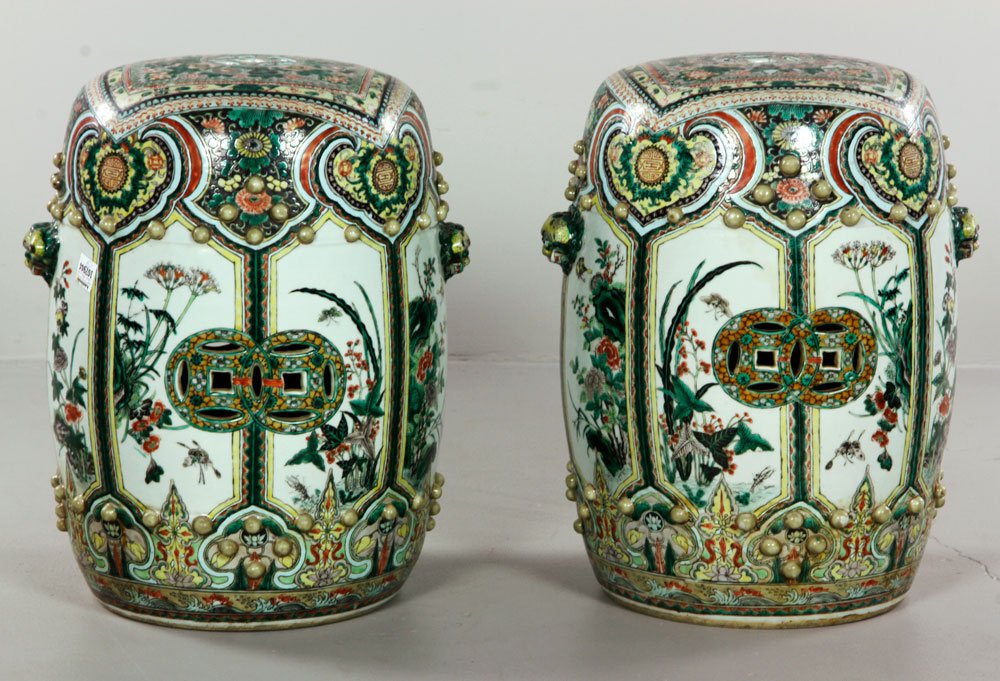 Chinese Famille Verte Porcelain Stools: Pair of famille verte porcelain garden stools, China, the round forms decorated with a square design painted over it creating an unusual illusion, with cut-out double coin motif on the sides and singl