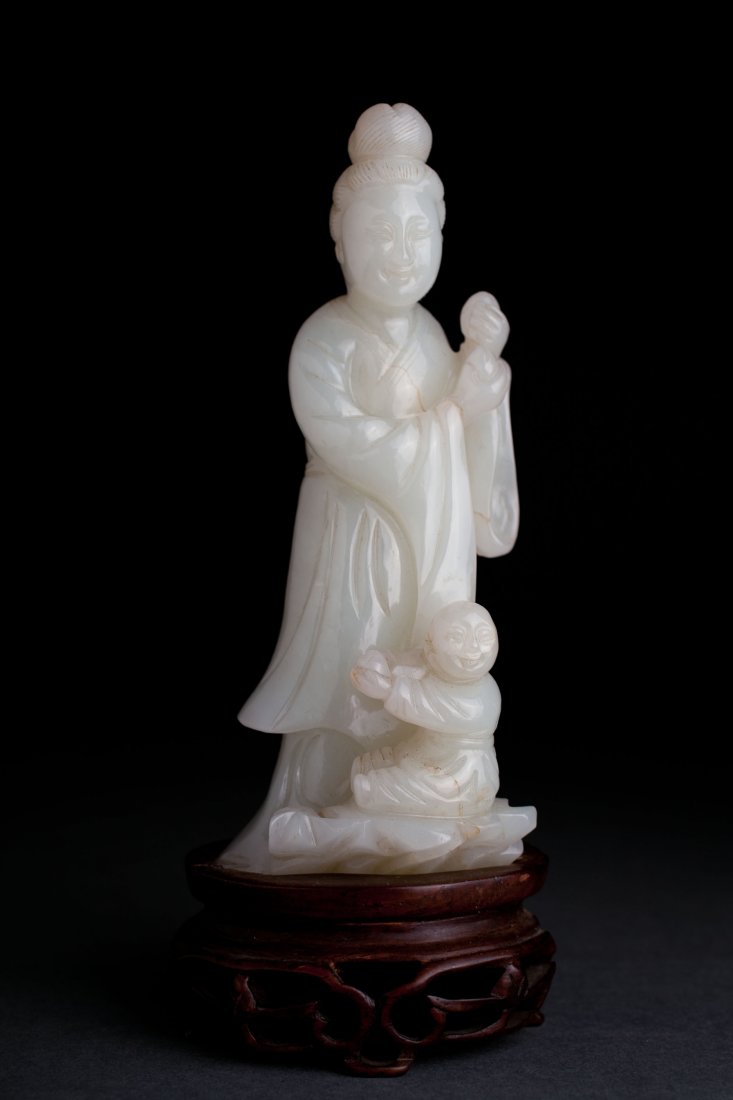 Antique Chinese White Jade Figure Qing 1644-1911: Antique Chinese White Jade Figure Qing 1644-1911 Carved in fine mutton fat white jade as a figure of a woman and child each holding peaches in their hands all on a wood stand. 5 1/4", (6 1/8" on stand