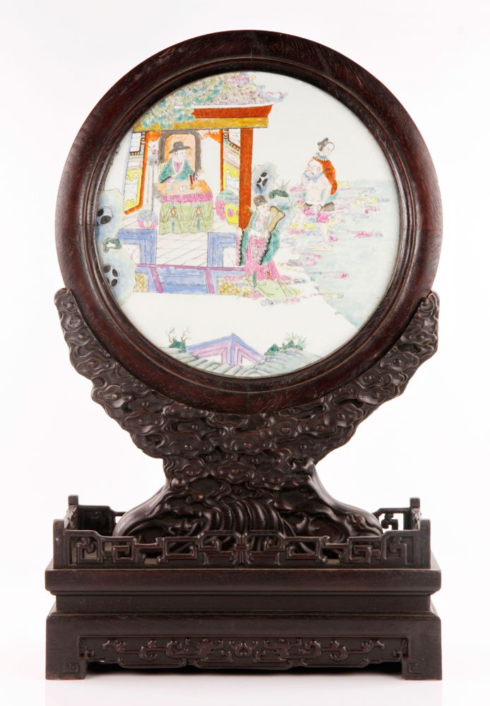 Chinese Hardwood Table Screen: Carved hardwood table screen, China, mounted with a round famille rose porcelain plaque, 26 1/2” x 16”.