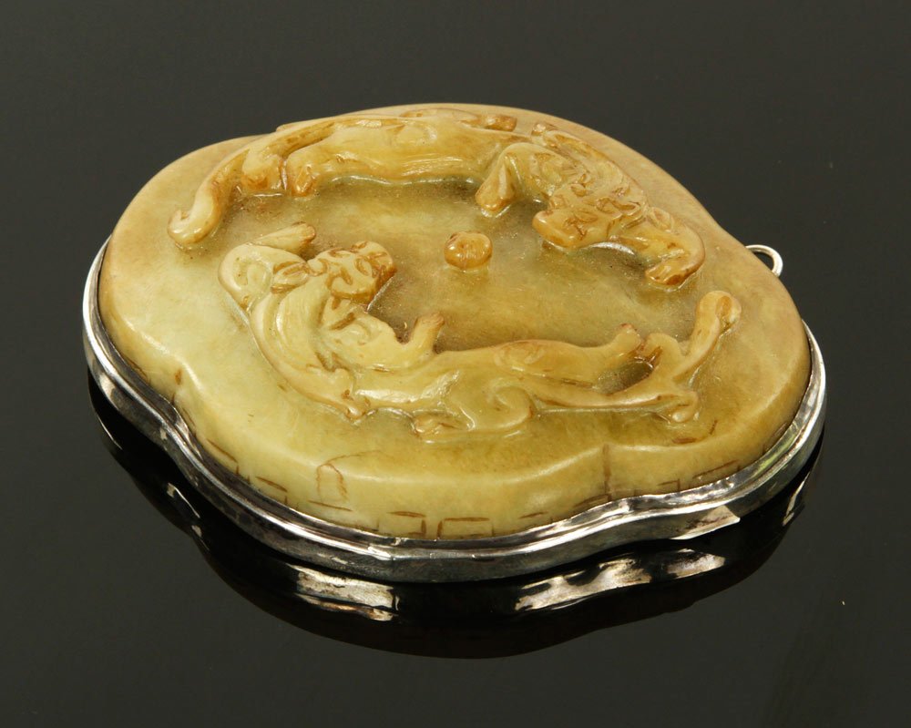 Chinese Carved Jade Medallion: Carved jade medallion, with stamped sterling silver, China, 3 1/2'' h x 4 3/4'' w. Provenance: From the collection of Surin Namkunee of Florida.
