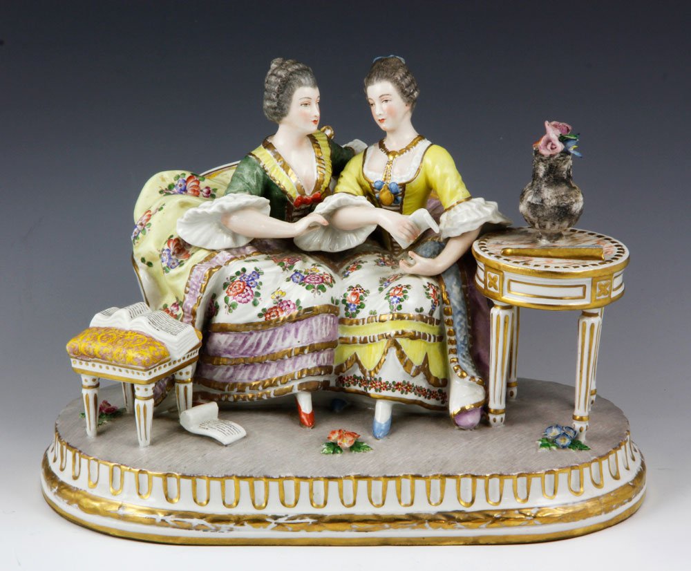 Paris Porcelain Figure Group: French Paris Porcelain figure group of two ladies, both in ornate 18th century dresses, seated on a settee, one reading a letter, flanked by a stool and table, 7" h x 10" l. Provenance: From a Murriet
