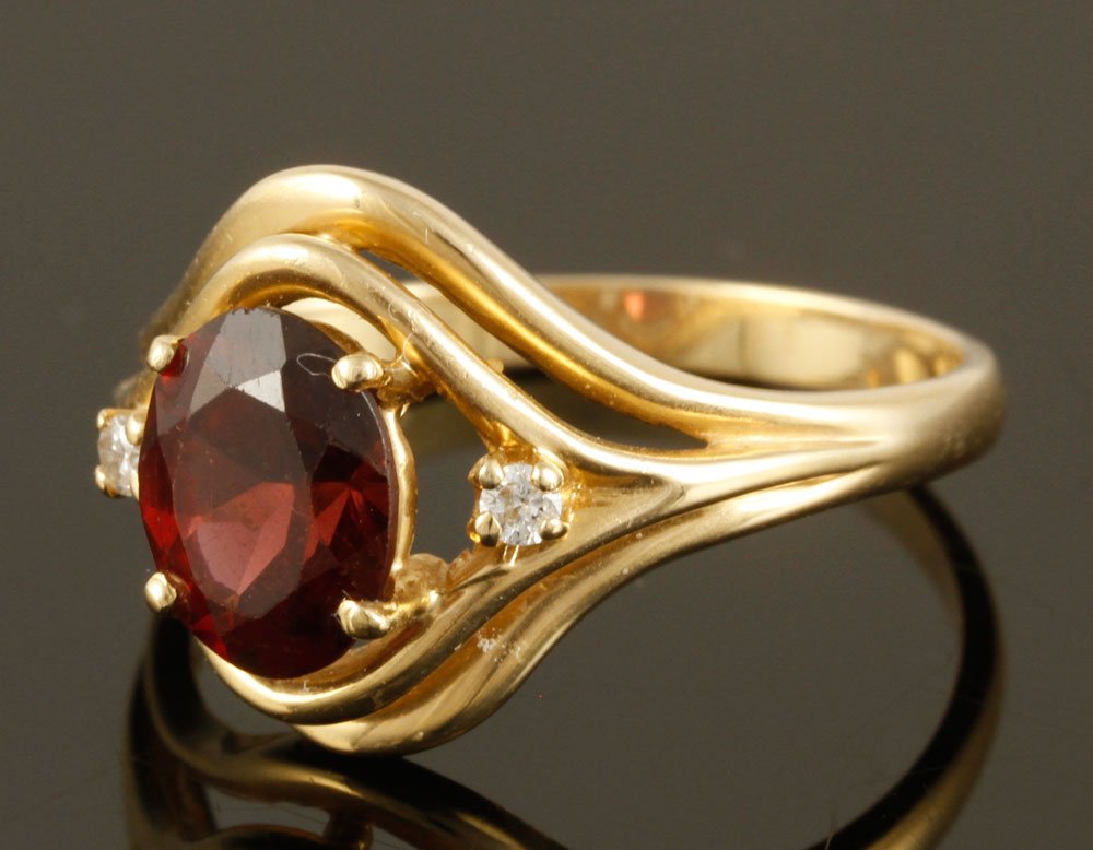14K Diamond and Garnet Ring: 14K gold ladies' ring, with oval garnet and two diamonds on either side, approximately .2 ounces/ 3 DWT TW, size 9 1/2. Provenance: From a Billerica, MA estate.