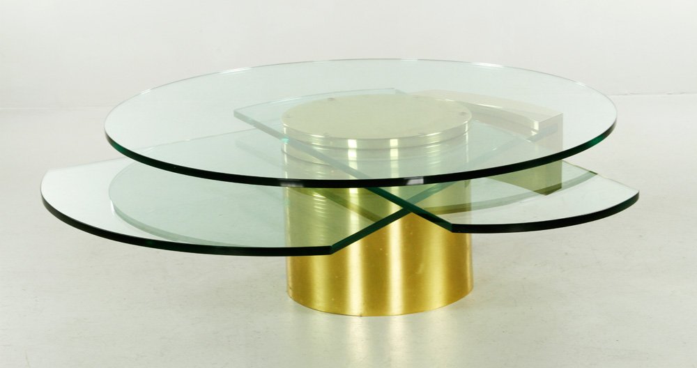Jackson, "Self Winding Coffee Table," Glass and Brass: Dakota Jackson (American, 20th C.) "Self Winding" coffee table, brass with glass top, 17" h x 58 1/2" dia. Provenance: From a New York City, NY estate.