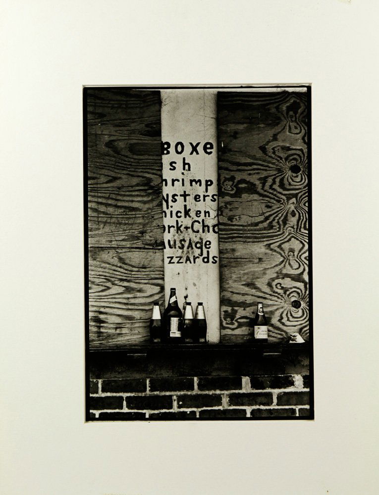 Rauschenberg, Untitled, Photograph: Robert Rauschenberg (American, 1925 - 2008), untitled, black and white photograph, depicting several bottles against plywood sheets covering list of food, unframed, signed in pen lower left, affixed i