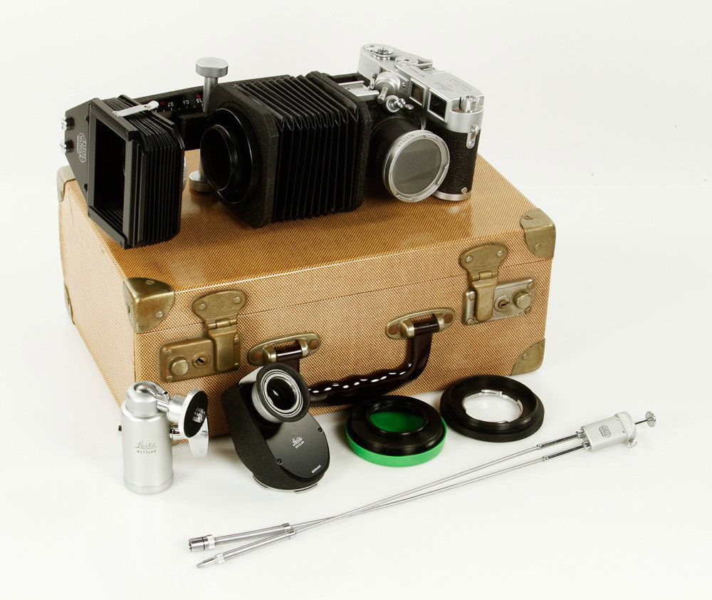 Leica M-3 Camera: Leica M-3 Camera, in original carrying case, low serial number 873291, with Leitz Wetzlar eye piece, and tripod mount, Ernst Leitz GmBH lens with extra expandable bellows shutter release. Provenance: