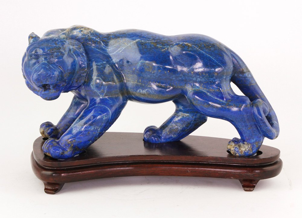 Chinese Lapis Figure: Carved sodalite lapis figure of a lion, China, on wood base, 6"h x 11 1/2"w. Provenance: From the estate of Raymond Bolduc of Fort Lauderdale, Florida and Ogunquit, Maine.
